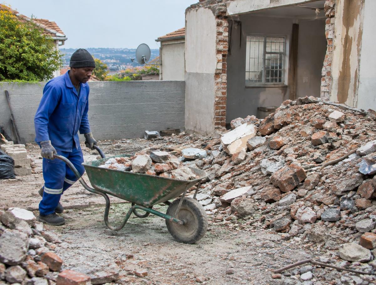 Building rubble being cleared by wheelbarrow